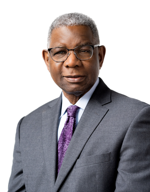 Clarence Barry-Austin in a suit and purple tie wearing glasses