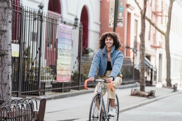 A woman is riding a bike down a city street.
