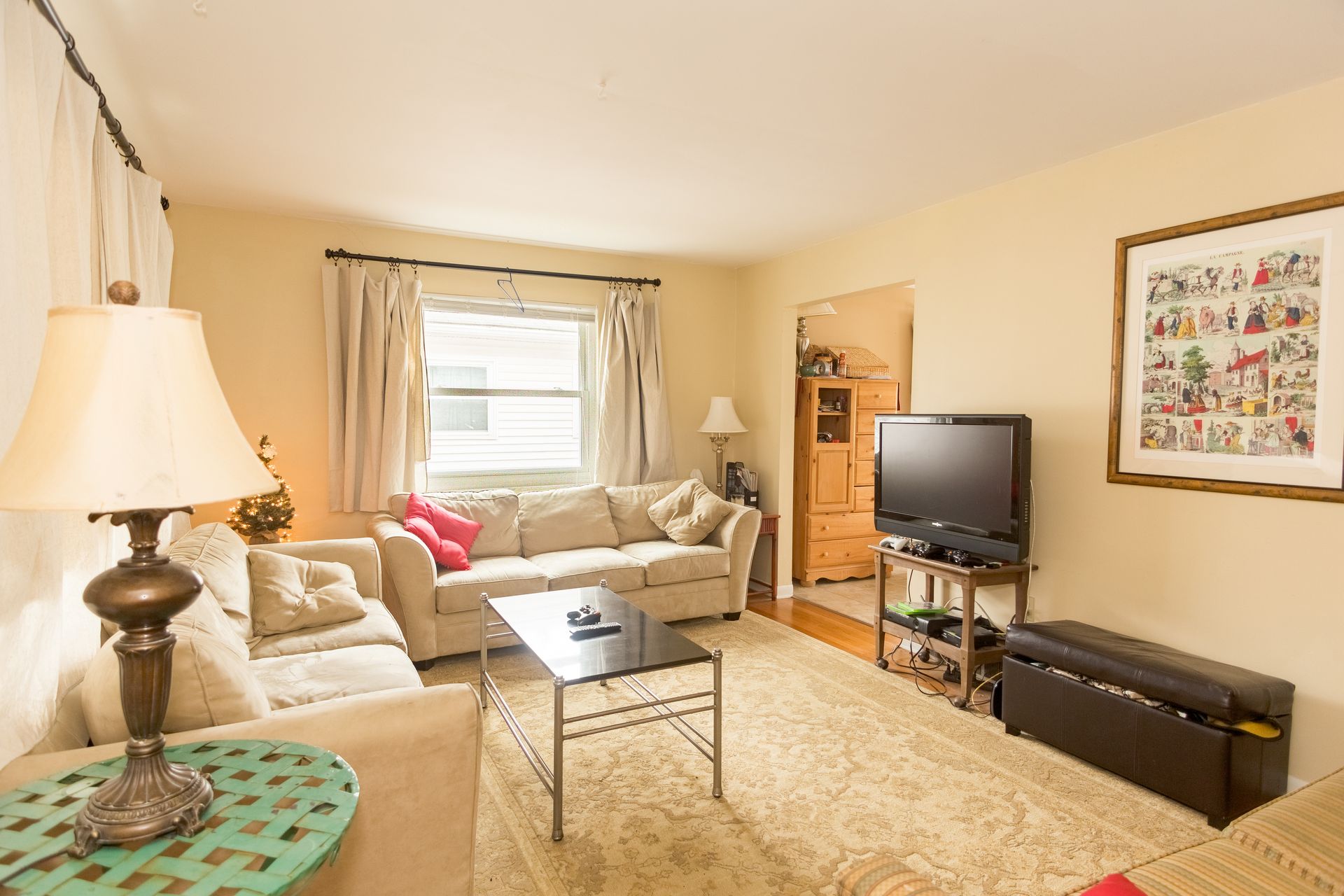 A living room with a couch , table , lamp and television.