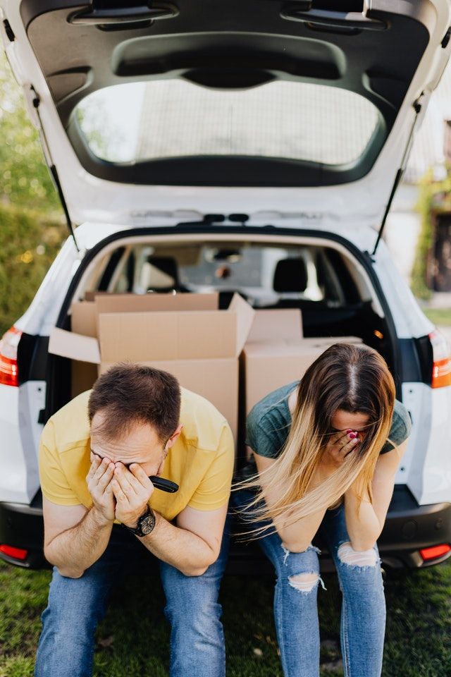 A man and a woman are sitting in the back of a car.