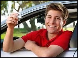 A young man is sitting in a car holding a car key.