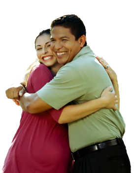 A man in a green shirt is hugging a woman in a red dress
