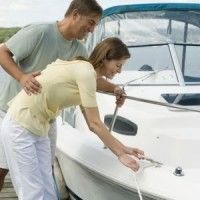 A man and a woman are standing next to a boat.