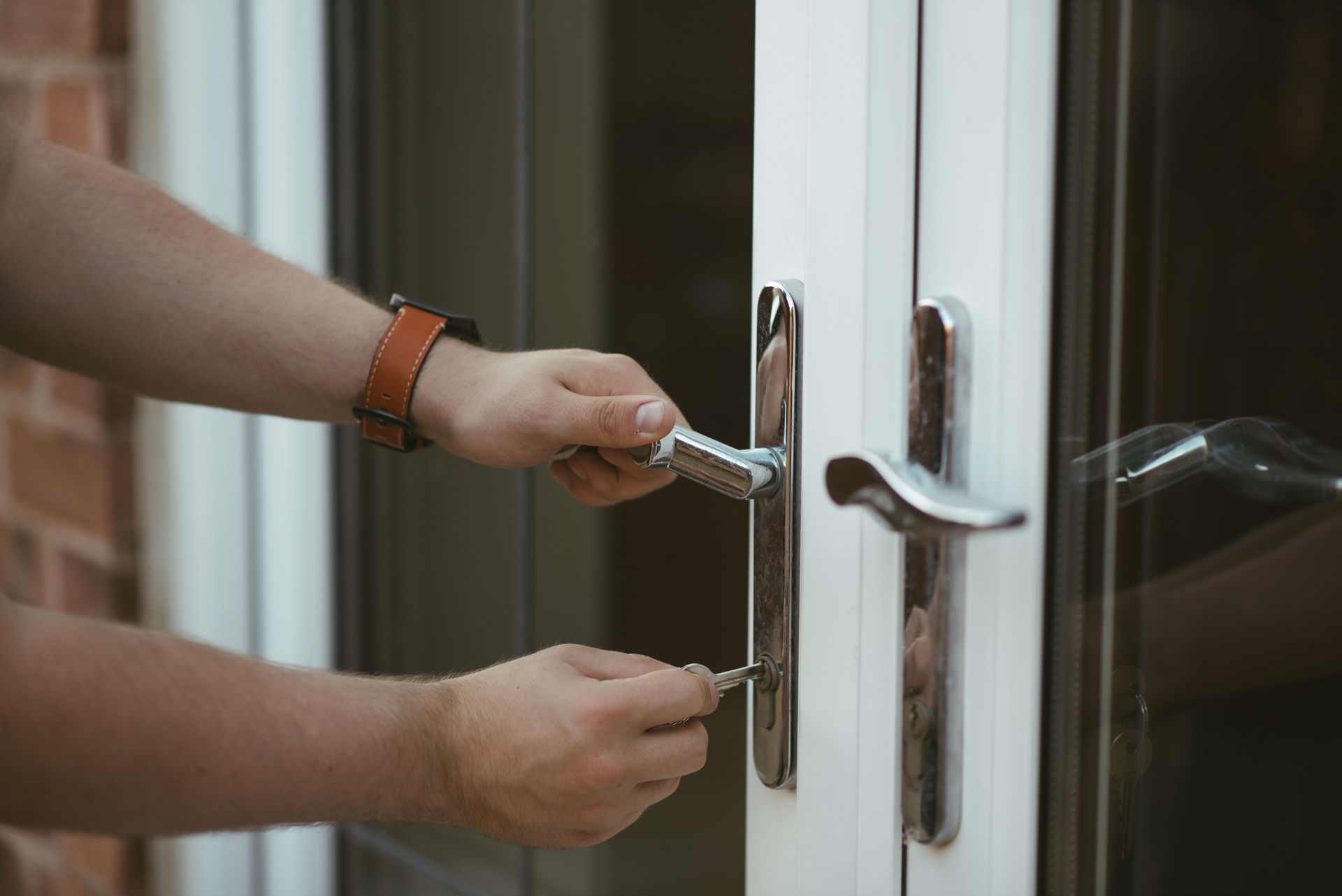 A person is opening a door with a key.