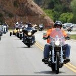 A group of people are riding motorcycles down a road.