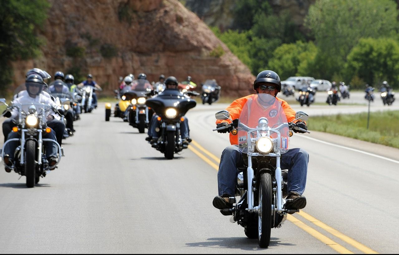 A group of people are riding motorcycles down a road