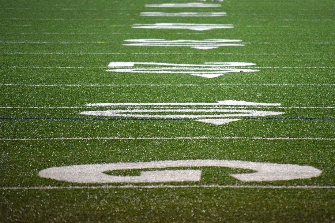 A football field with the letter g painted on it in the rain.