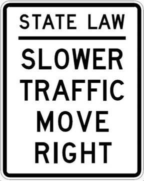 A black and white sign that says `` state law slower traffic move right ''.