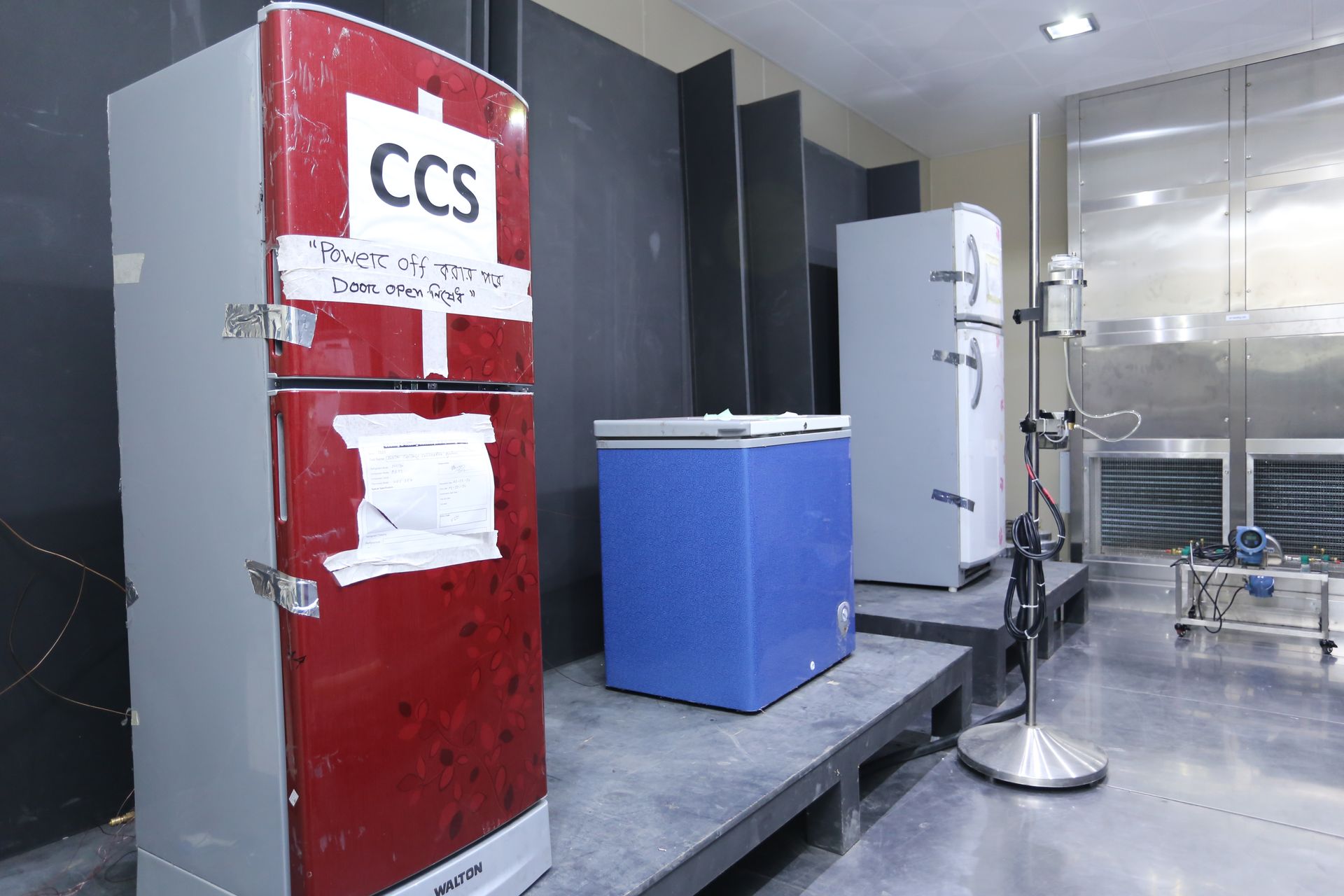 Laboratory room with red CCS freezer, blue chest freezer, and stainless steel equipment