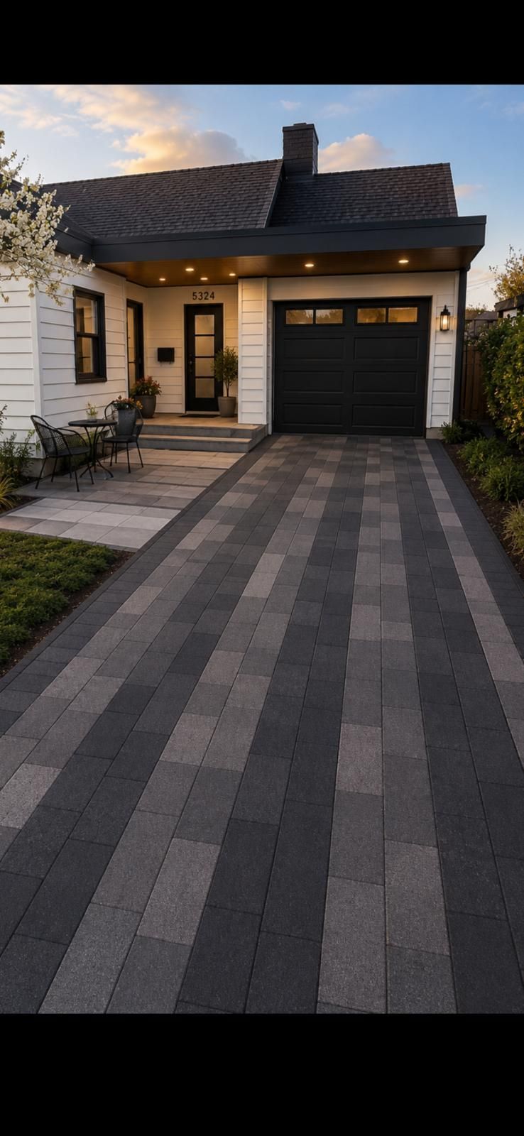 Modern house with dark striped driveway, single garage, and front entry at dusk