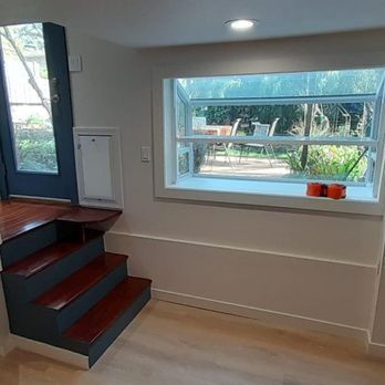 Modern interior with a small staircase, built-in window seat, and large window overlooking a garden