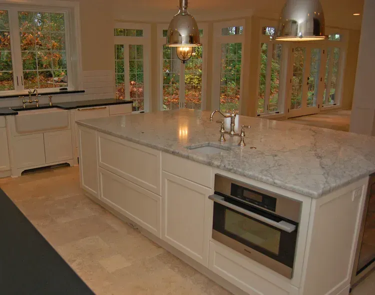 Modern kitchen with large island, granite countertop, pendant lights, and stainless-steel appliances