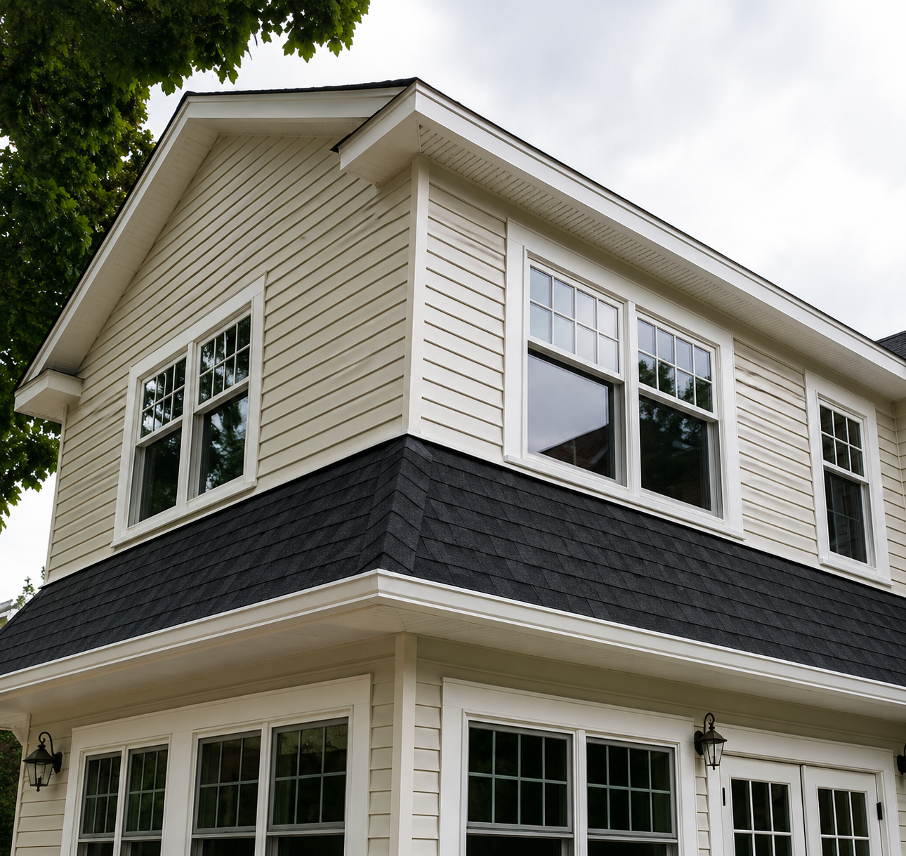 Two-story white house with dark trim and multiple windows viewed from below