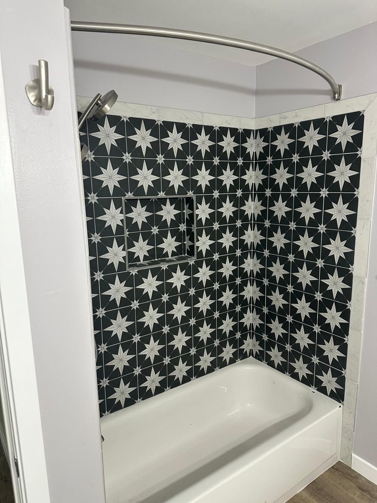 Bathroom with star-patterned shower curtain and tiled tub enclosure