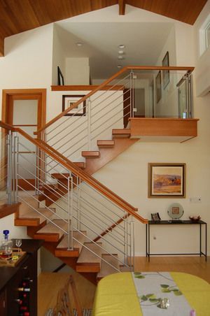 Modern home interior with a staircase, wooden railings, and vaulted ceiling