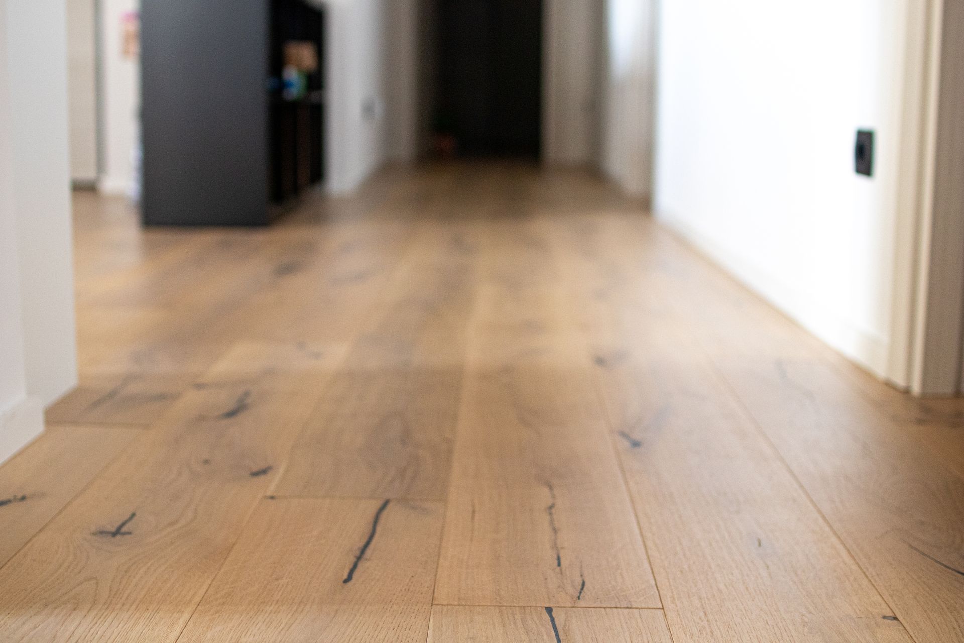 Close-up of oak parquet boards showing dark veins and a rough finish