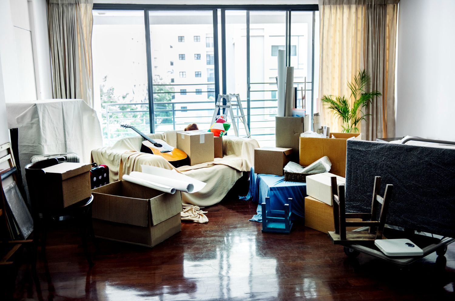 Messy apartment living room filled with cardboard packing boxes and leftover belongings requiring a professional apartment cleanout service in Smyrna GA