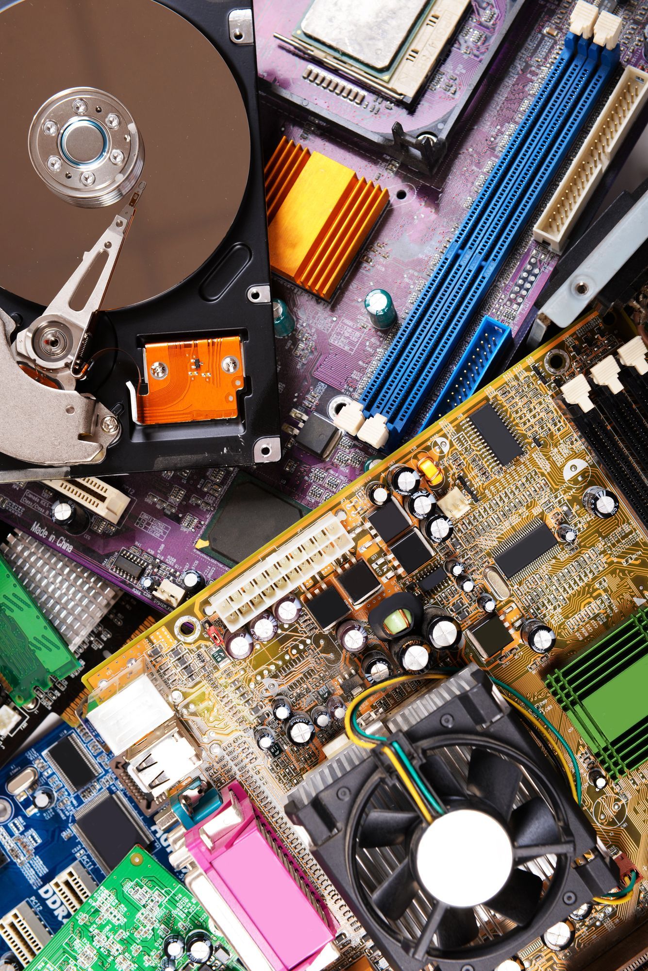 Disassembled computer circuit boards open hard drive and electronic components ready for electronic waste recycling and electronics pickup in Smyrna GA