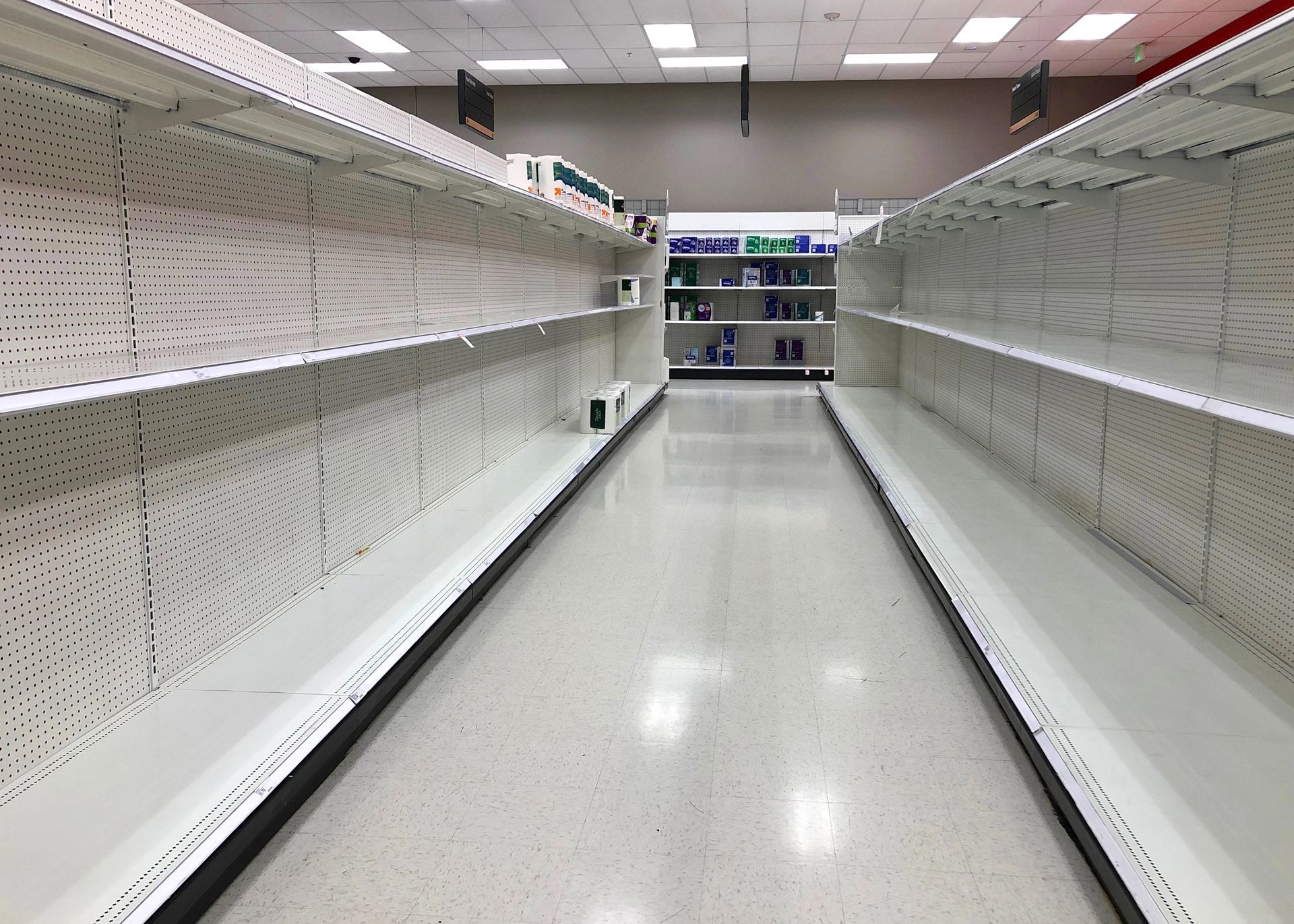Empty white shelving aisles inside a closed retail store needing commercial fixture removal services in Smyrna GA