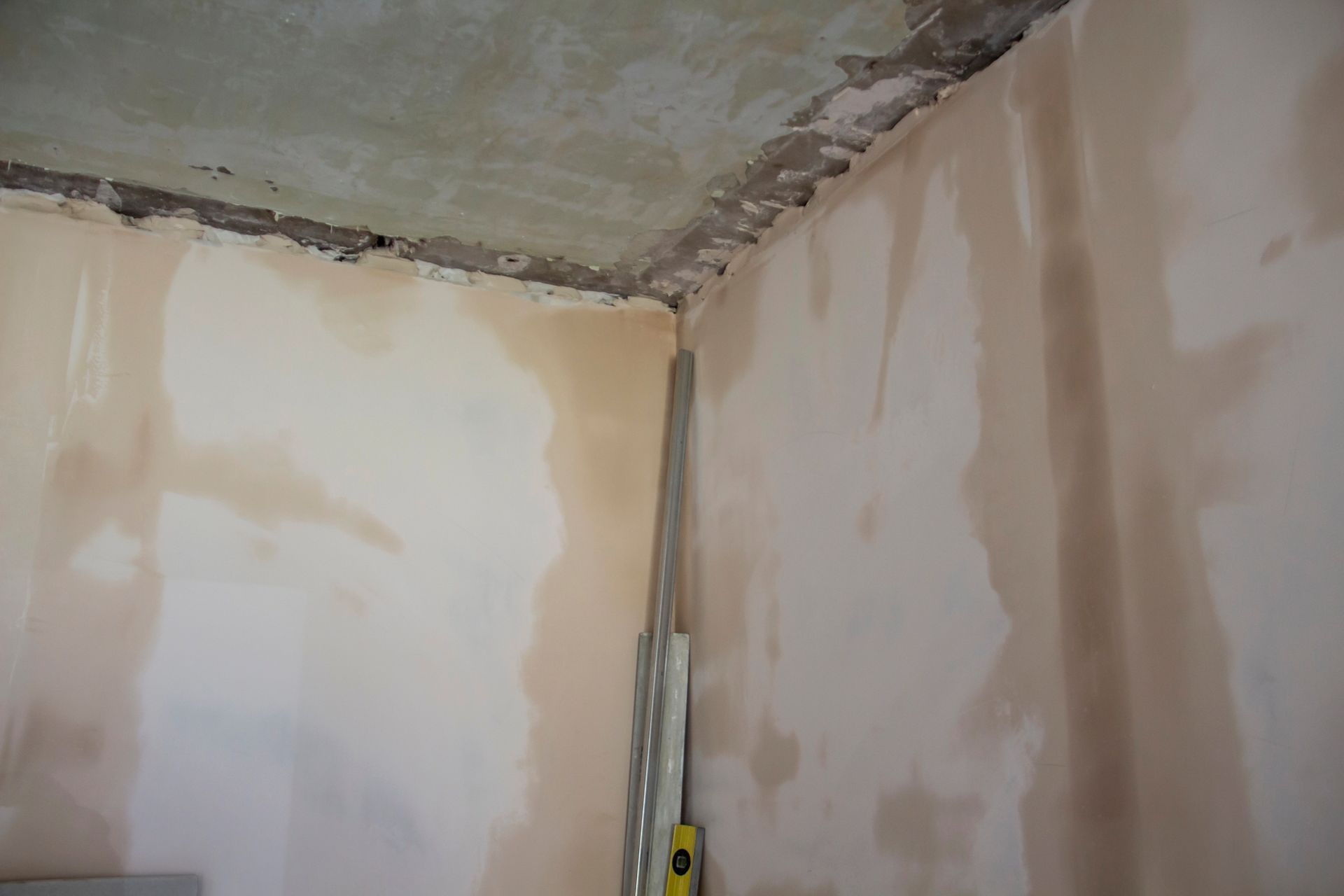 Corner of a residential room showing severe drywall water damage and an exposed ceiling edge requiring professional cleanup services in Smyrna GA