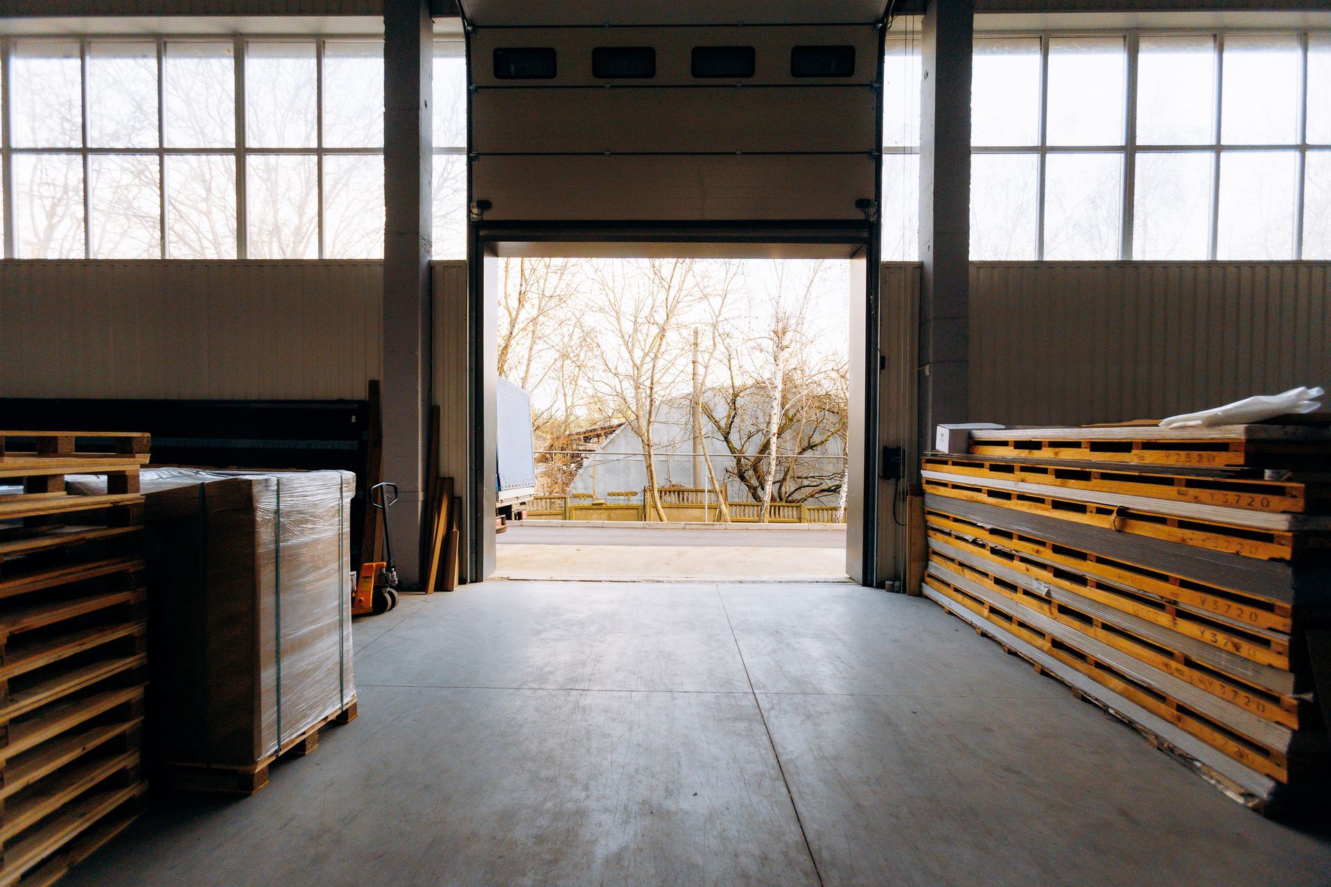 Stacked wooden pallets and freight inside an open warehouse loading dock ready for commercial pallet pickup in Smyrna GA