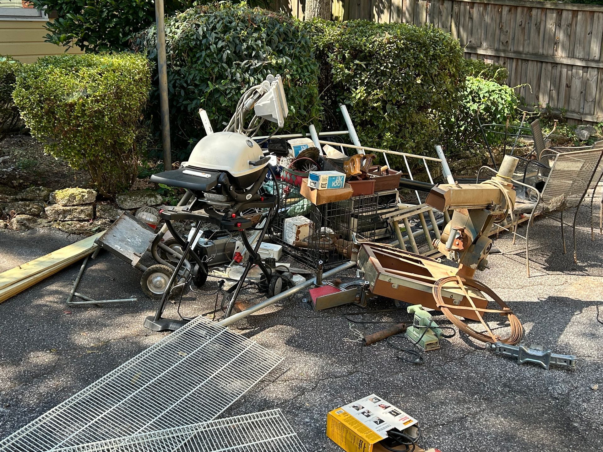 Pile of discarded household junk including an outdoor grill wire shelving and scrap wood waiting for residential debris removal in Smyrna GA