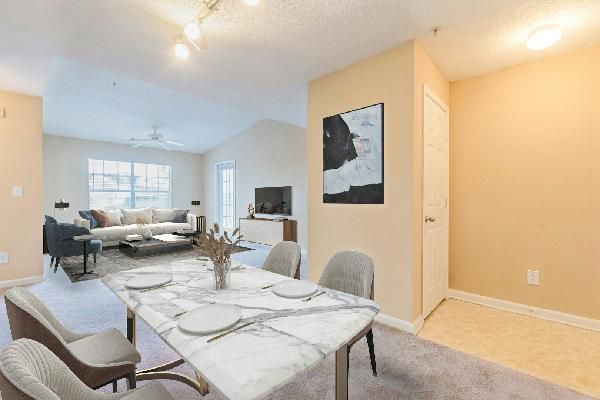White kitchen with stainless steel appliances, cabinets, and light gray countertops.