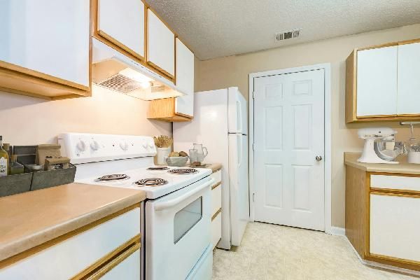A small, modern kitchen with stainless steel appliances and white cabinets.
