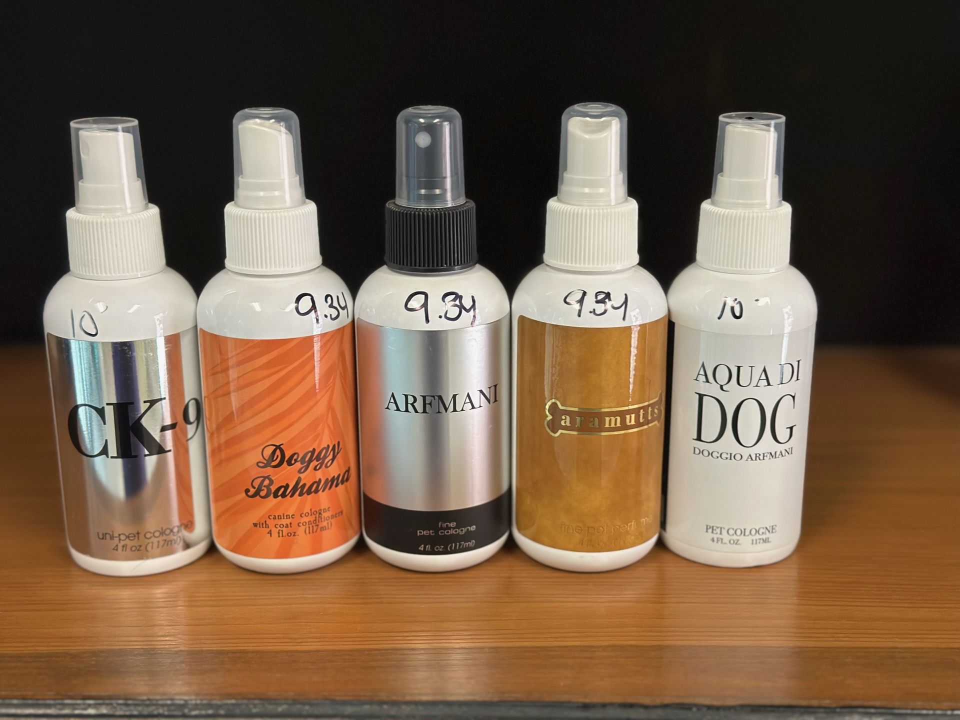 A row of spray bottles sitting on top of a wooden table.