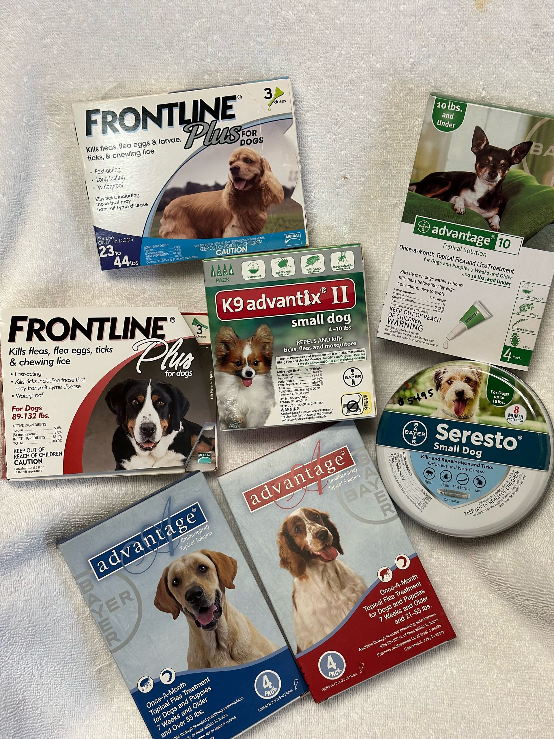 A variety of frontline products for dogs are sitting on a white towel.