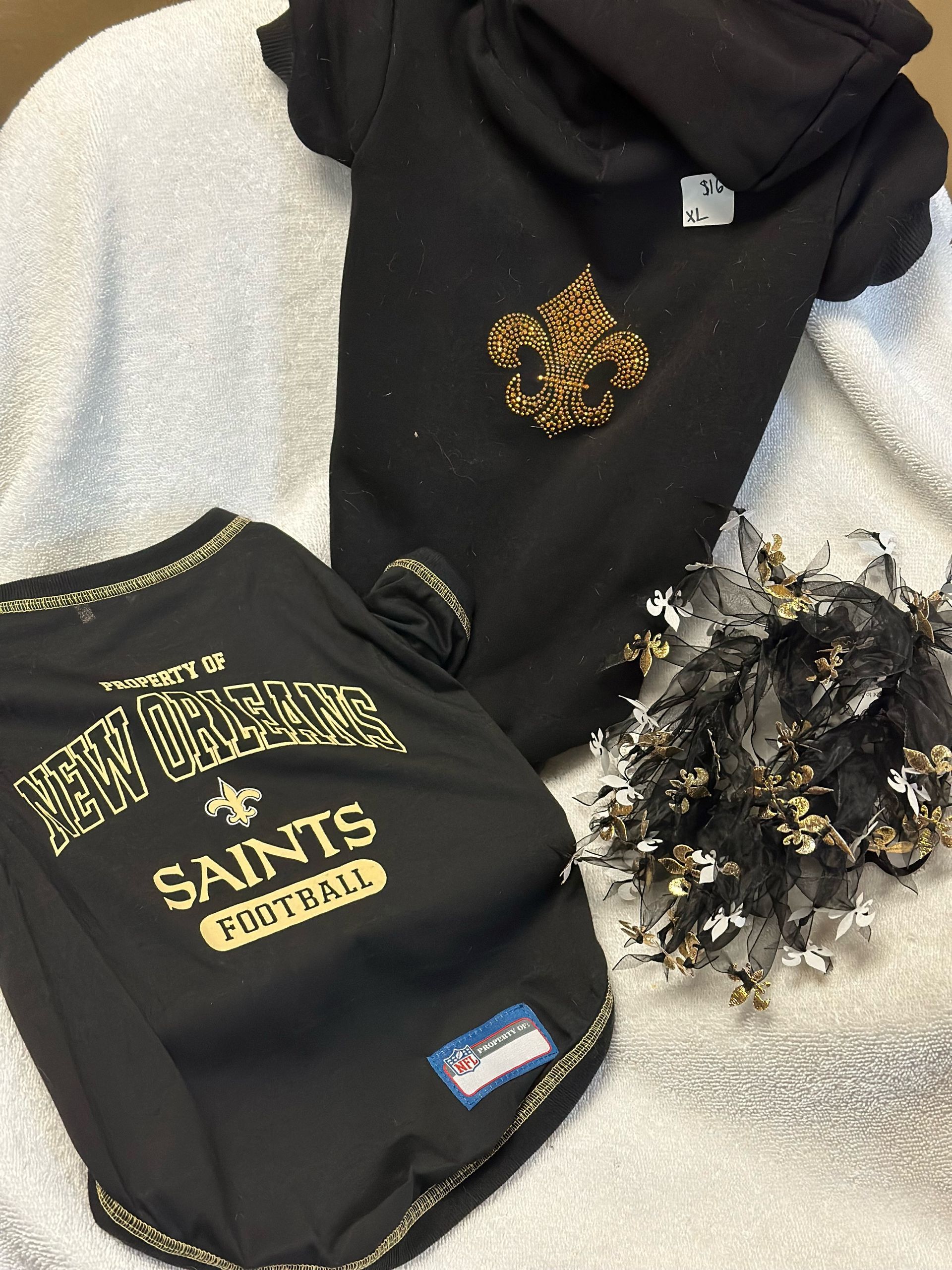 A black saints football shirt is on a white blanket