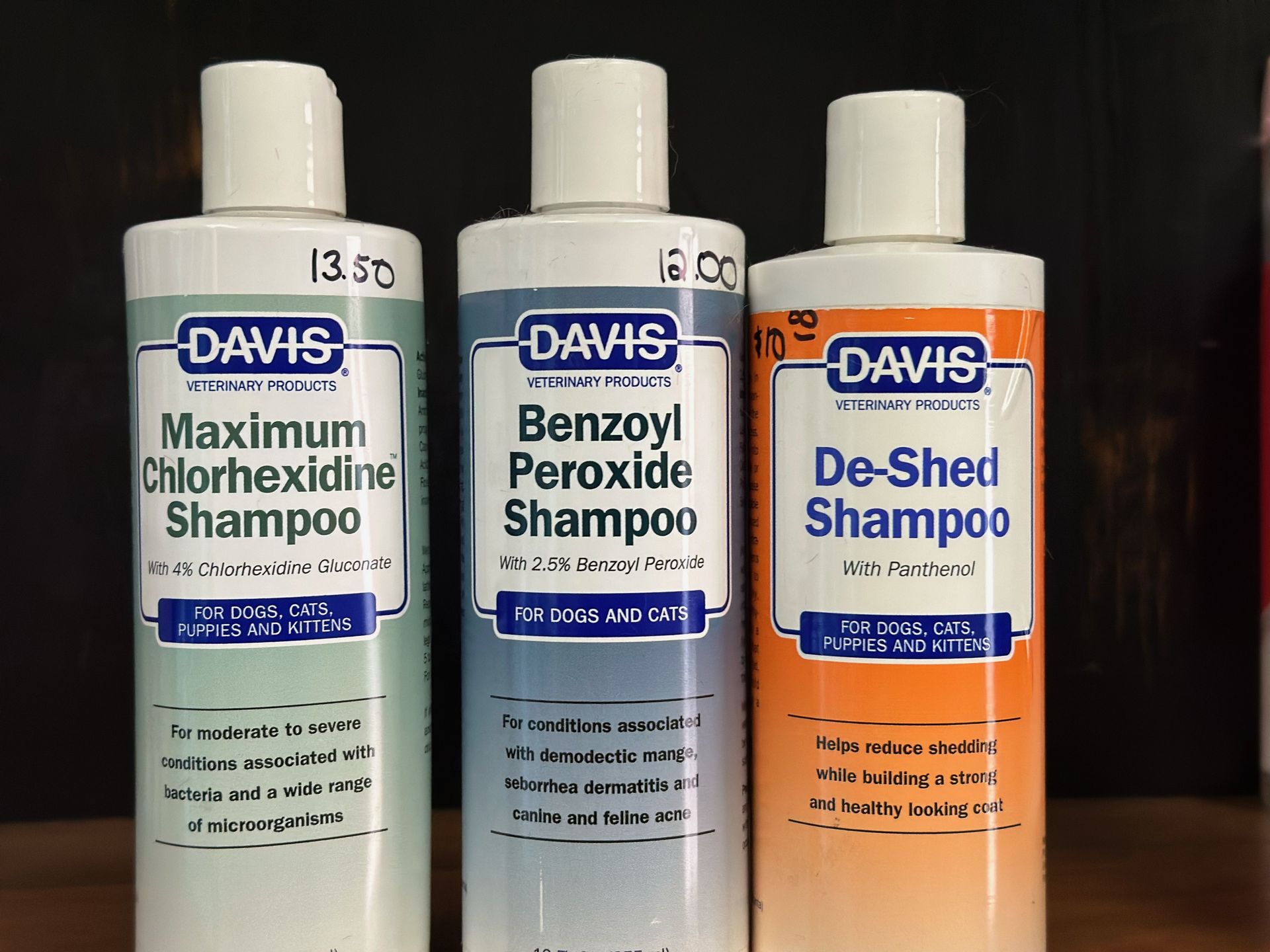 Three bottles of davis maximum chlorhexidine shampoo , benzoyl peroxide shampoo , and de-shed shampoo