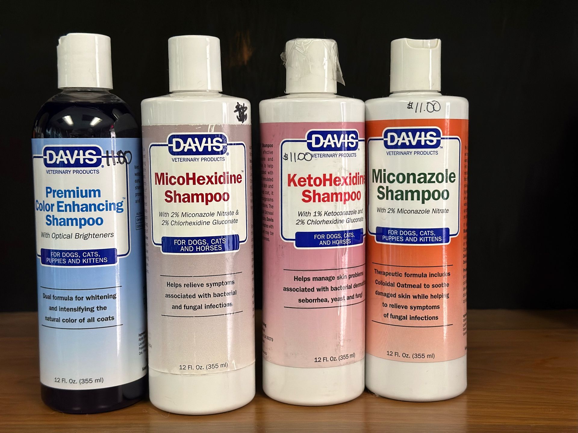 Four bottles of davis shampoo are lined up on a table