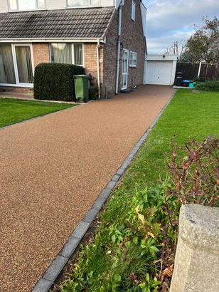 Resin driveway installation near Bristol, with light and dark aggregates mixed together.