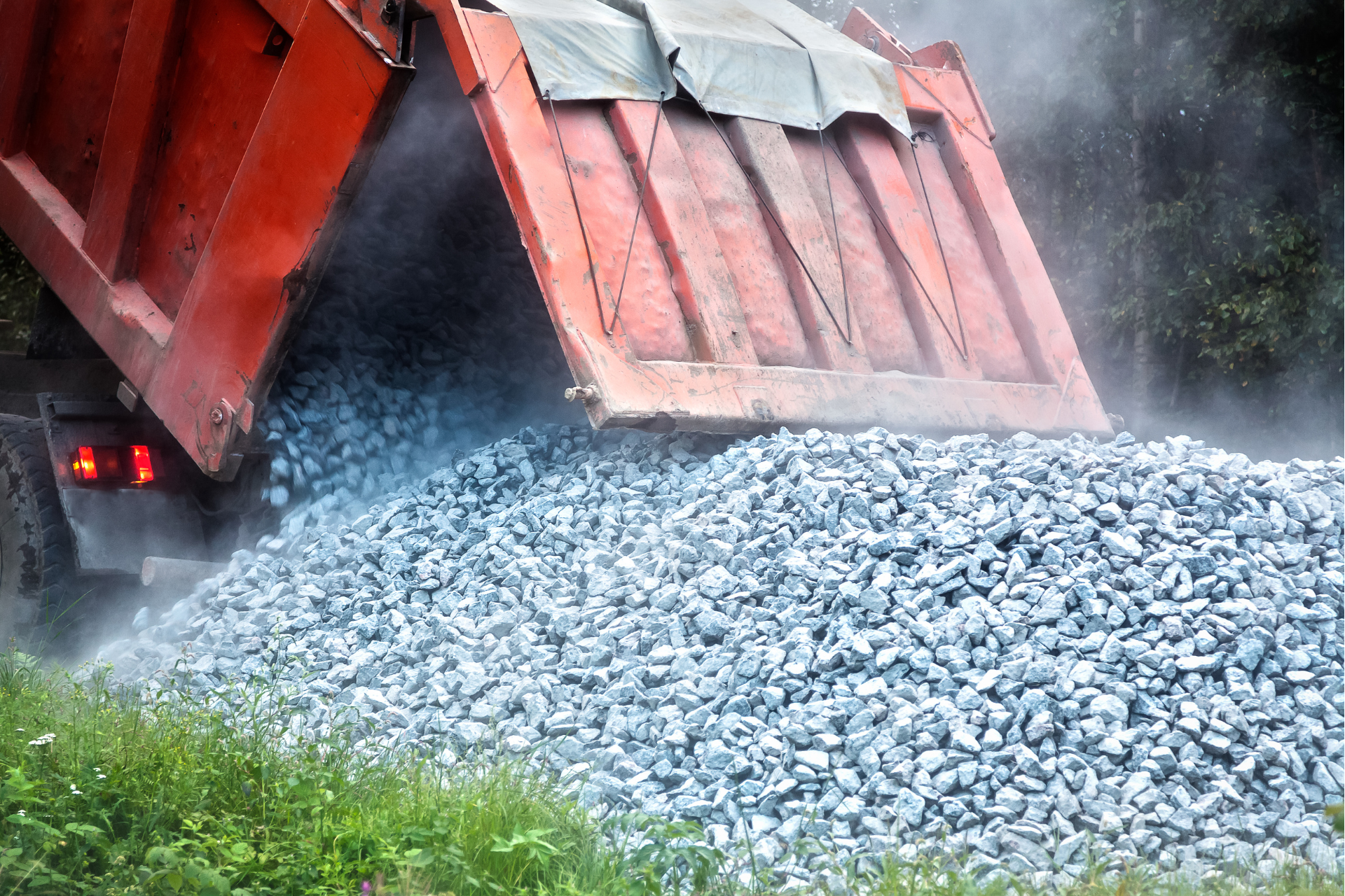 Learn More A dump truck is loading gravel into a pile.