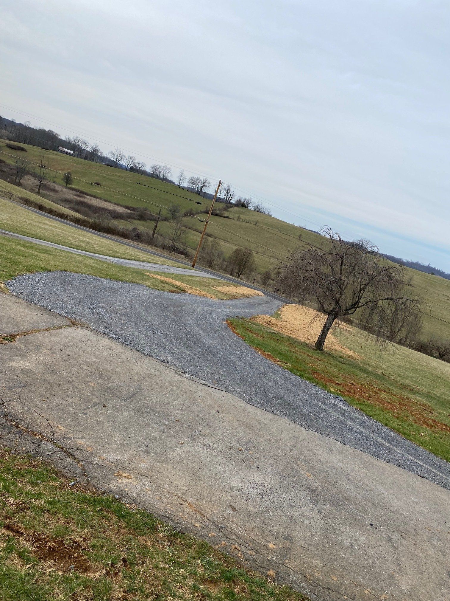 A gravel road going through a grassy field.