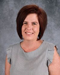 Woman smiling in front of gray backdrop