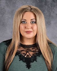 Woman smiling in front of gray backdrop