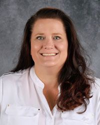Woman smiling in front of gray backdrop