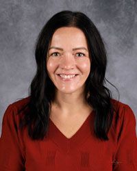 Woman smiling in front of gray backdrop