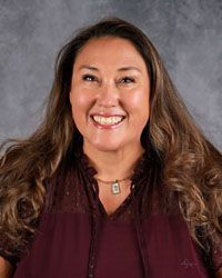 Woman smiling in front of gray backdrop