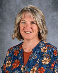 Woman smiling in front of gray backdrop