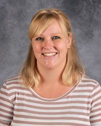 Woman smiling in front of gray backdrop