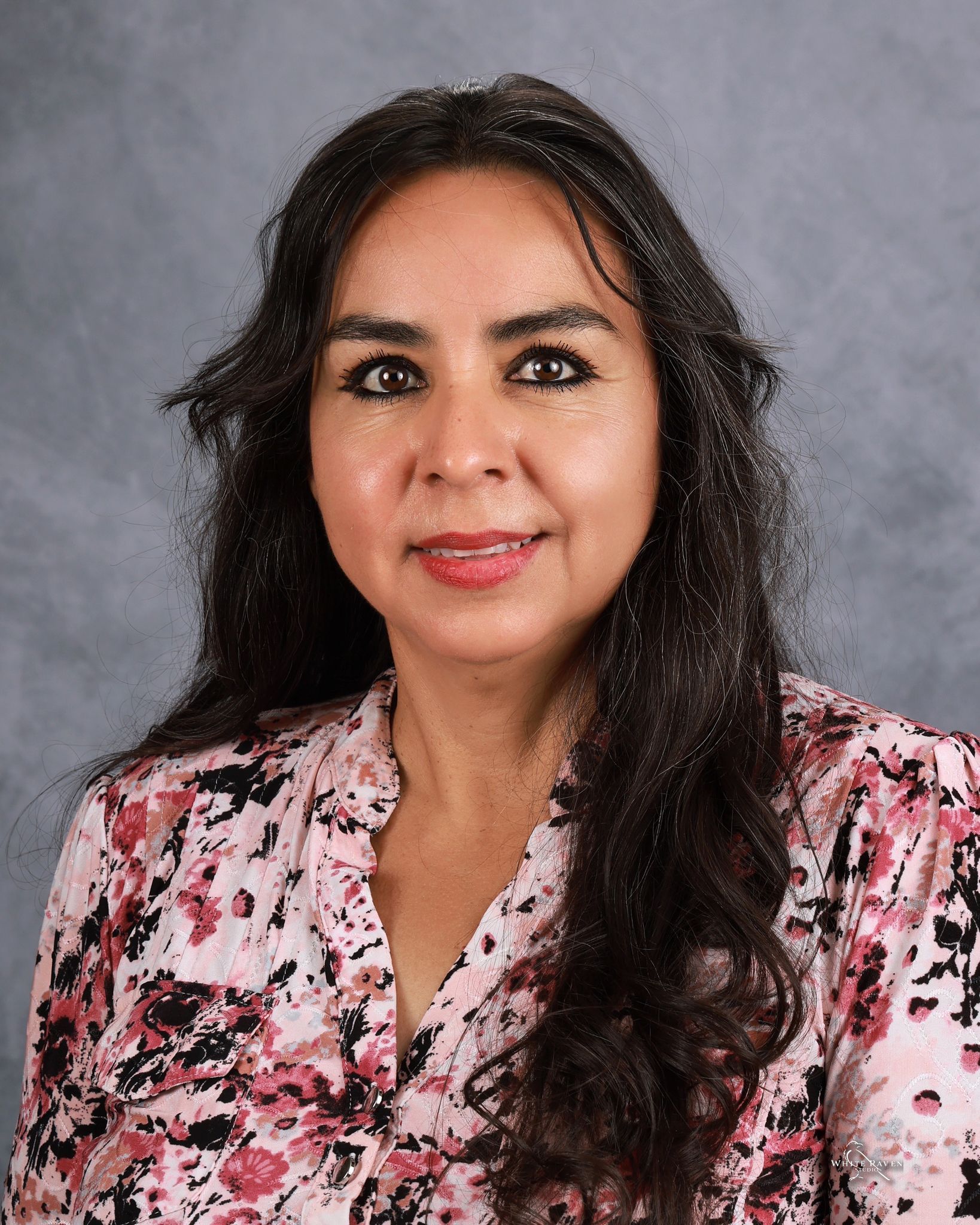 Woman smiling in front of gray backdrop