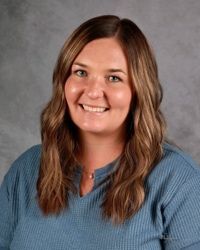Woman smiling in front of gray backdrop