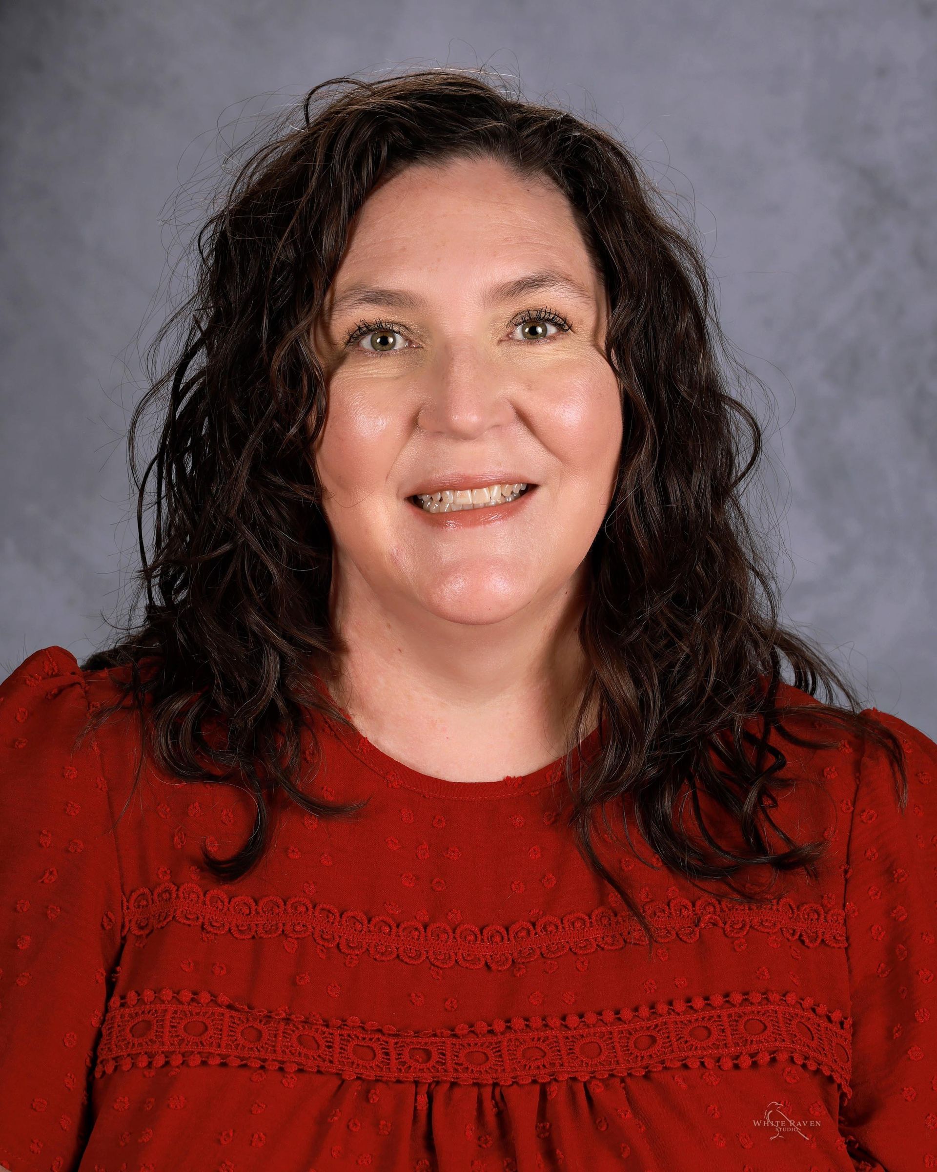 Woman smiling in front of gray backdrop