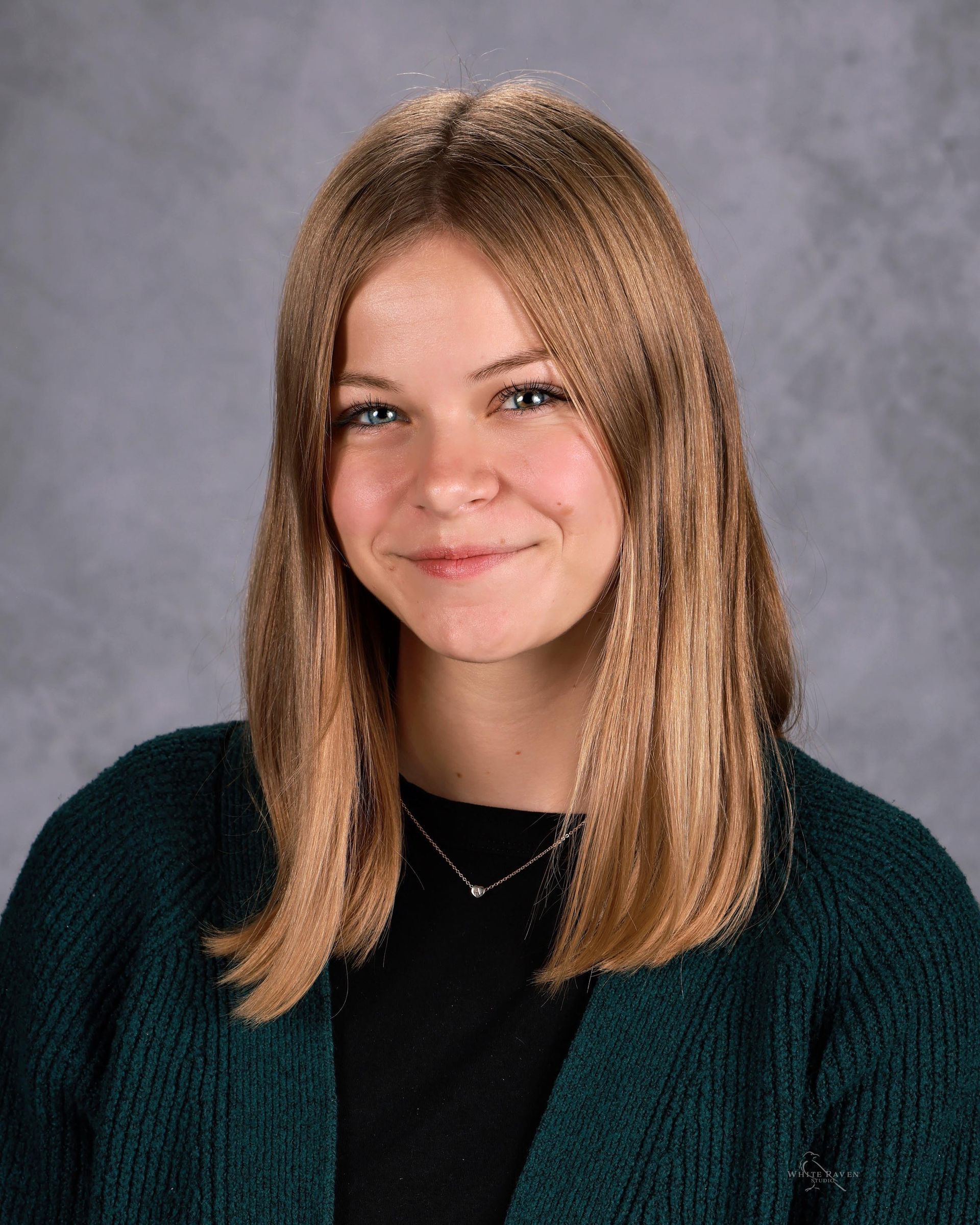 Woman smiling in front of gray backdrop