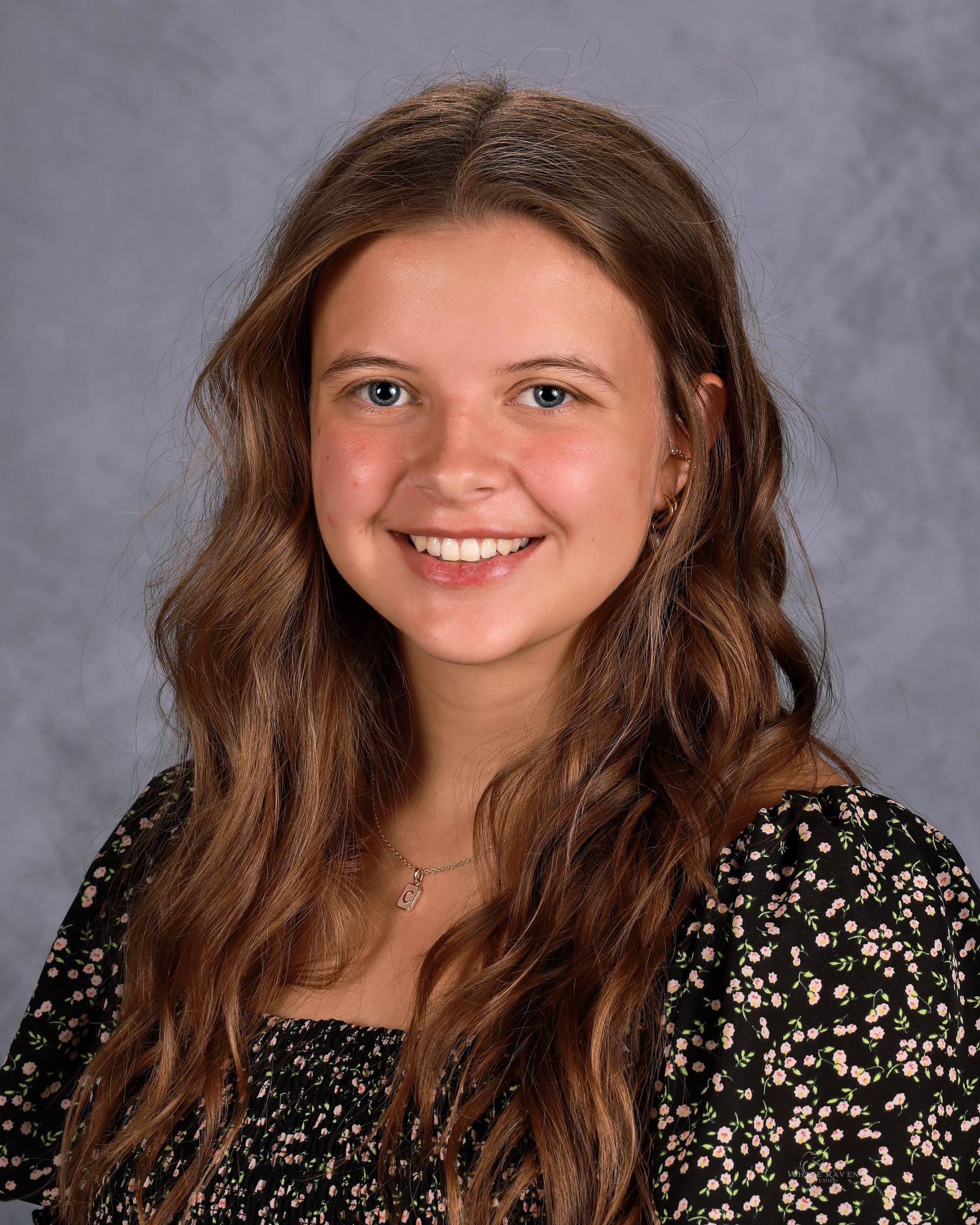 Woman smiling in front of gray backdrop