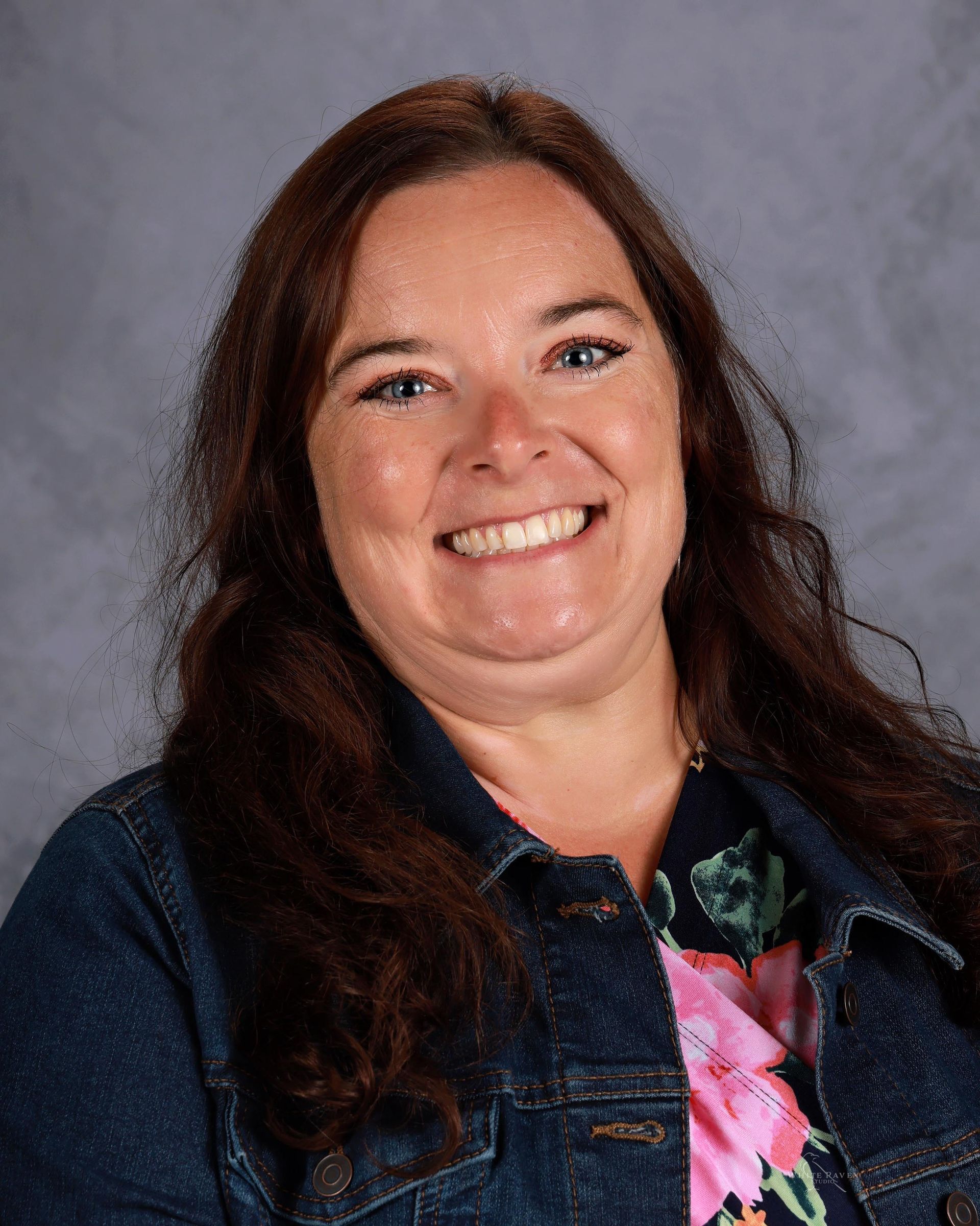 Woman smiling in front of gray backdrop
