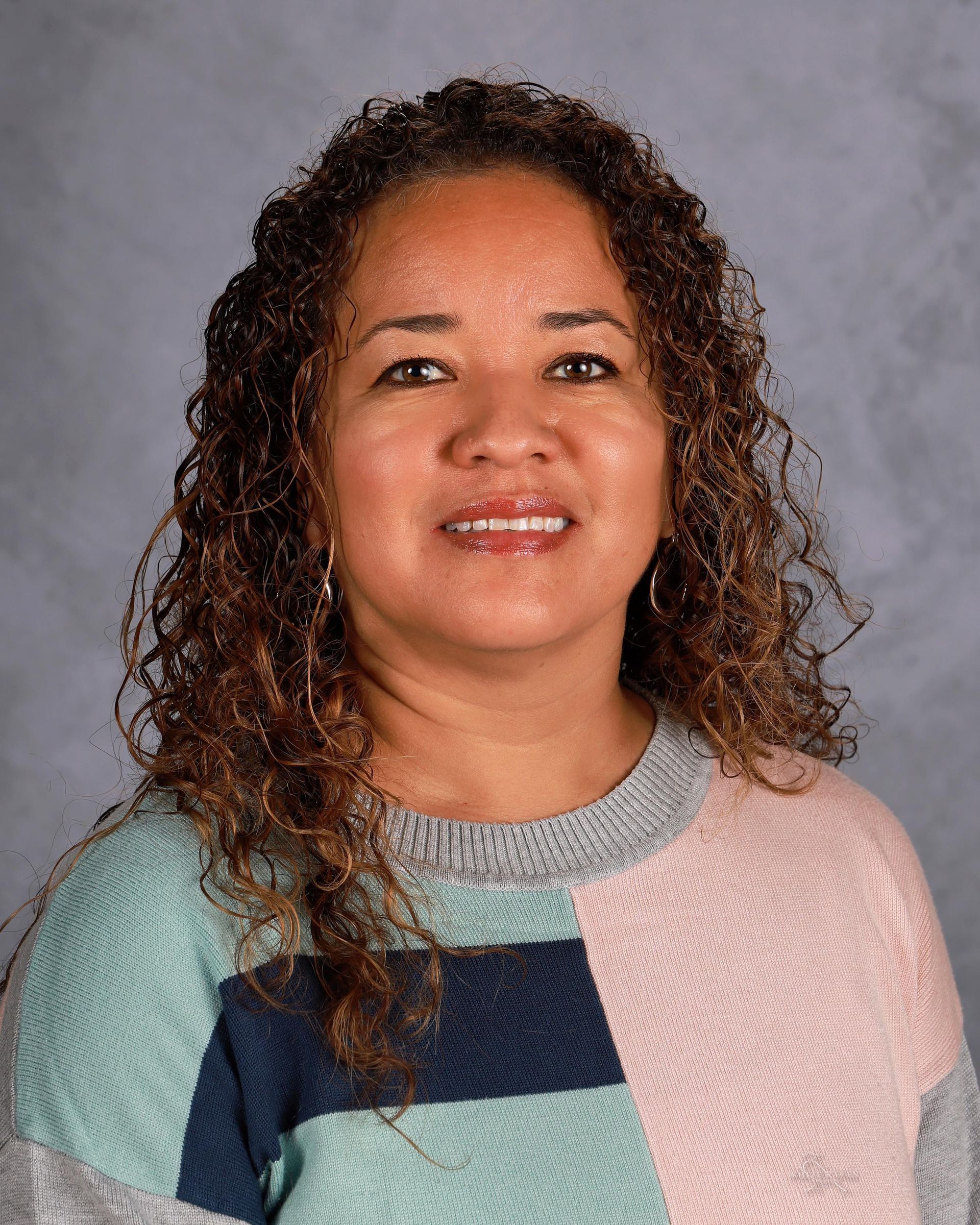 Woman smiling in front of gray backdrop